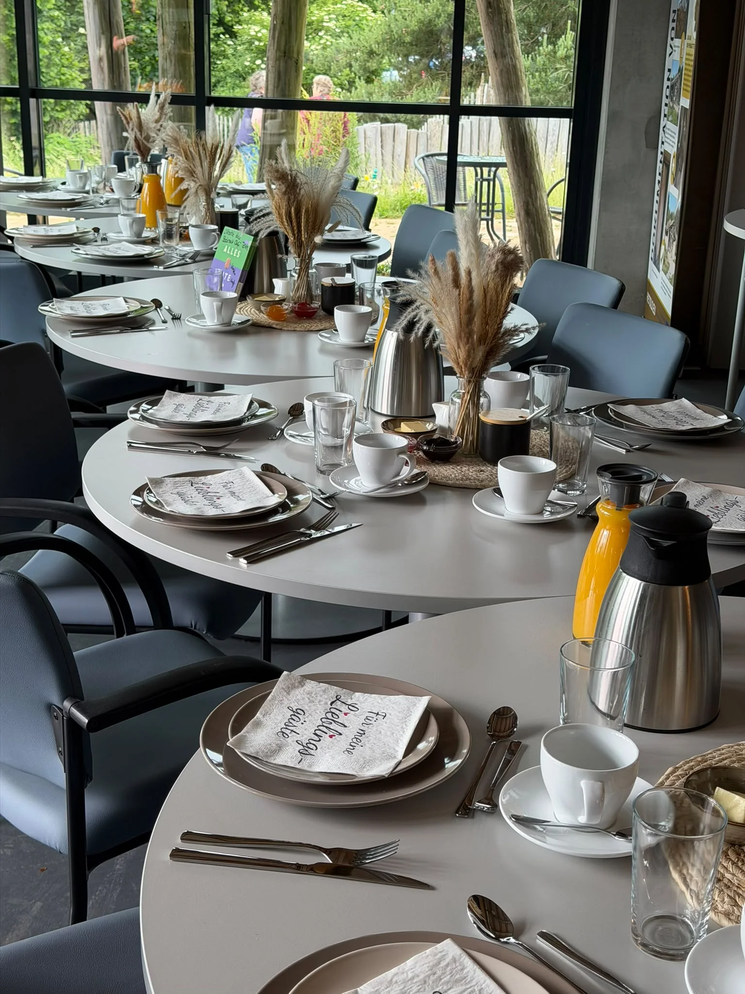 Gedeckte Cafétische im Steinzeit-Cafe mit Blick ins Grüne